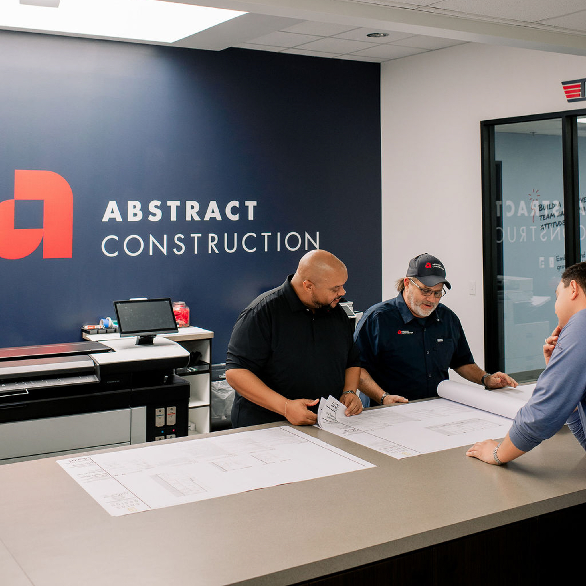 Lou Cardenas, Robert McDonald, and Cole Read reviewing plans for an interior project at 23 Springs