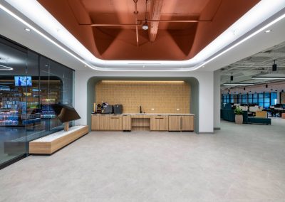 Vusion coffee bar with wood cabinetry, mustard tile backsplash, and a terracotta ceiling framed by curved lighting